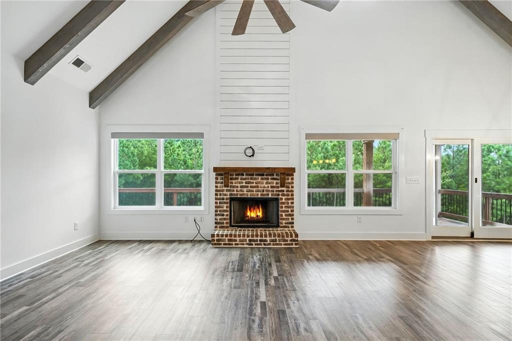 548 Stoneledge Road Jasper, GA 30143 - Photo 4 of 46 an empty room with wooden floor windows and a fireplace