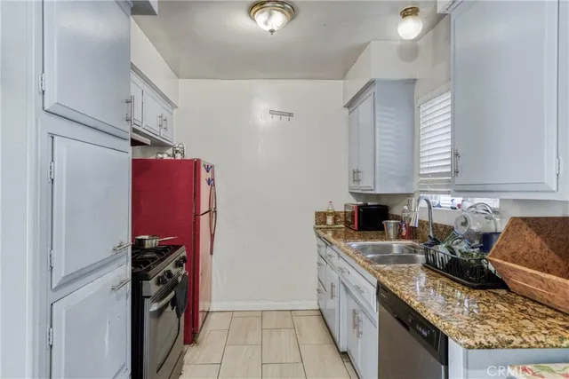 a kitchen with stainless steel appliances granite countertop a stove top oven a sink and dishwasher