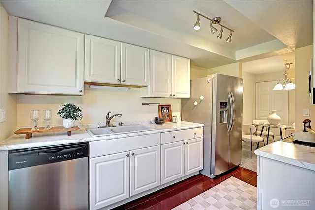 a kitchen with a sink dishwasher a refrigerator and cabinets