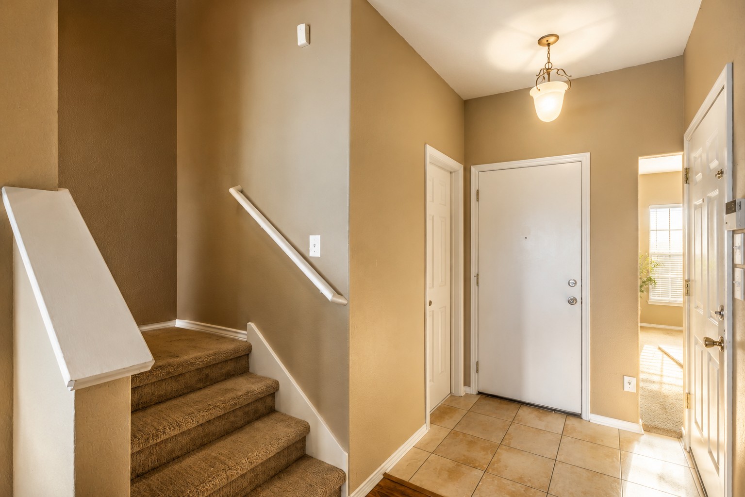 46 Verde Ranch Loop Leander, TX 78641 - Photo 5 of 19 Enter a warm interior with a carpeted staircase and tile flooring in the entry.