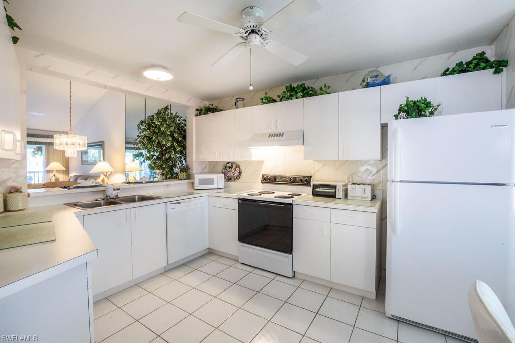 448 Gabriel Circle, Unit 3302 Naples, FL 34104 - Photo 12 of 32 a kitchen with a refrigerator and a sink