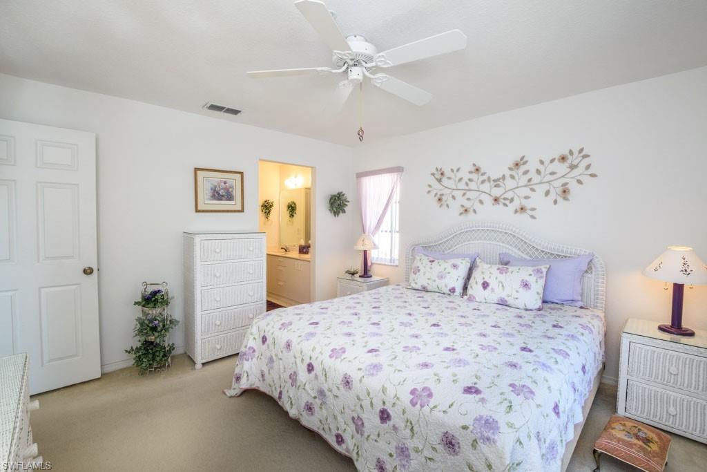 448 Gabriel Circle, Unit 3302 Naples, FL 34104 - Photo 15 of 32 a bedroom with a large bed and a chandelier