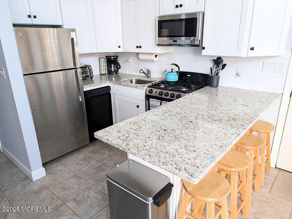 3170 Ocean Road Lavallette, NJ 08735 - Photo 5 of 13 a kitchen with stainless steel appliances granite countertop a refrigerator stove a sink dishwasher and microwave