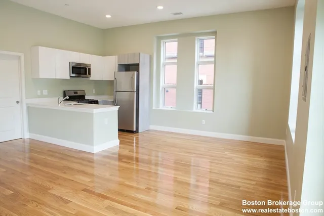a view of kitchen with stainless steel appliances granite countertop a stove top oven a sink and a refrigerator