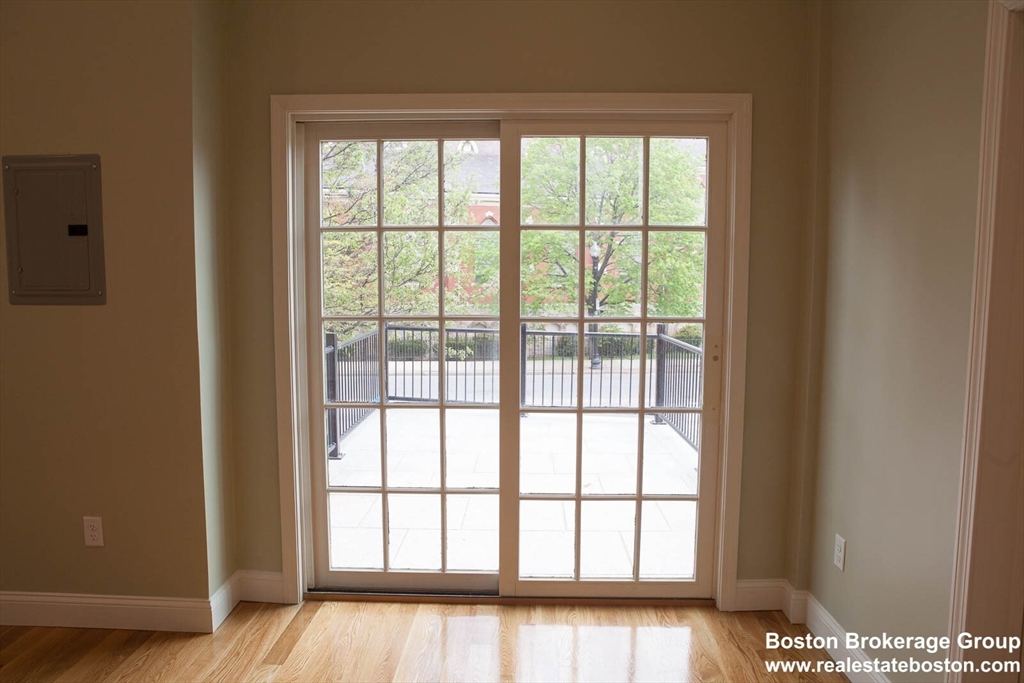 409 Dudley Street, Unit 1 Boston, MA 02119 - Photo 4 of 6 a view of an empty room with wooden floor and a window