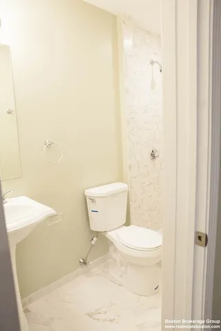 a white toilet sitting next to a white sink