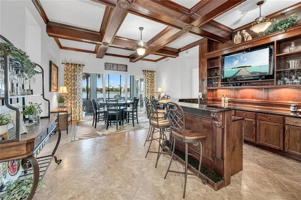 a view of a dining room with furniture a kitchen and chandelier