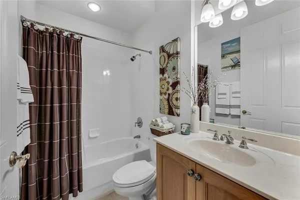 a bathroom with a granite countertop sink toilet a shower and a mirror