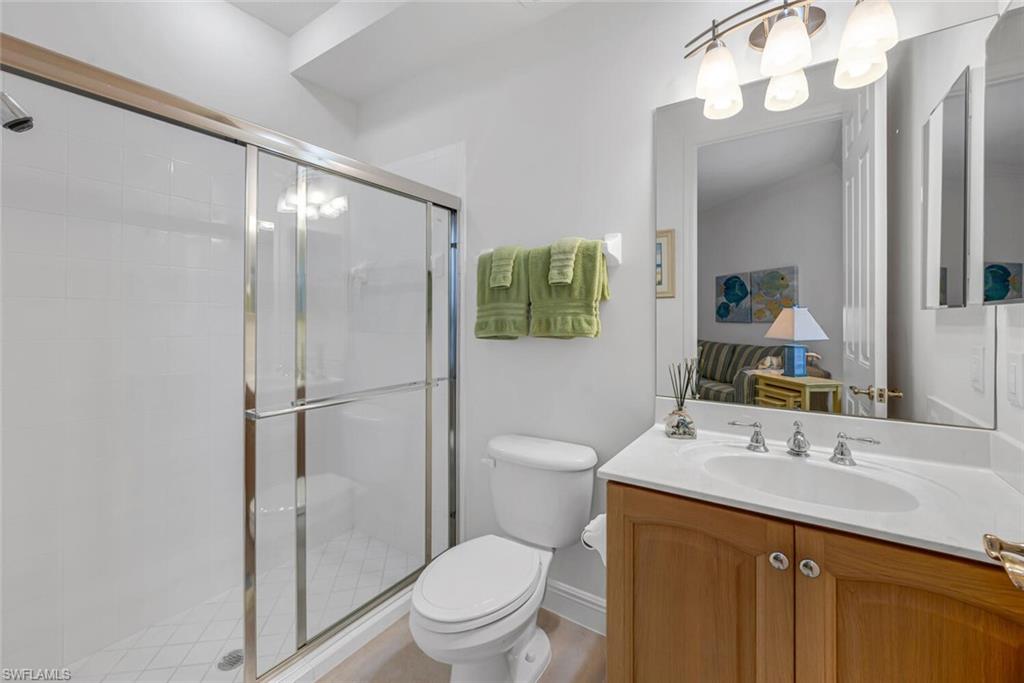 9243 Tesoro Lane, Unit 103 Naples, FL 34114 - Photo 14 of 18 a bathroom with a sink a toilet a mirror and shower