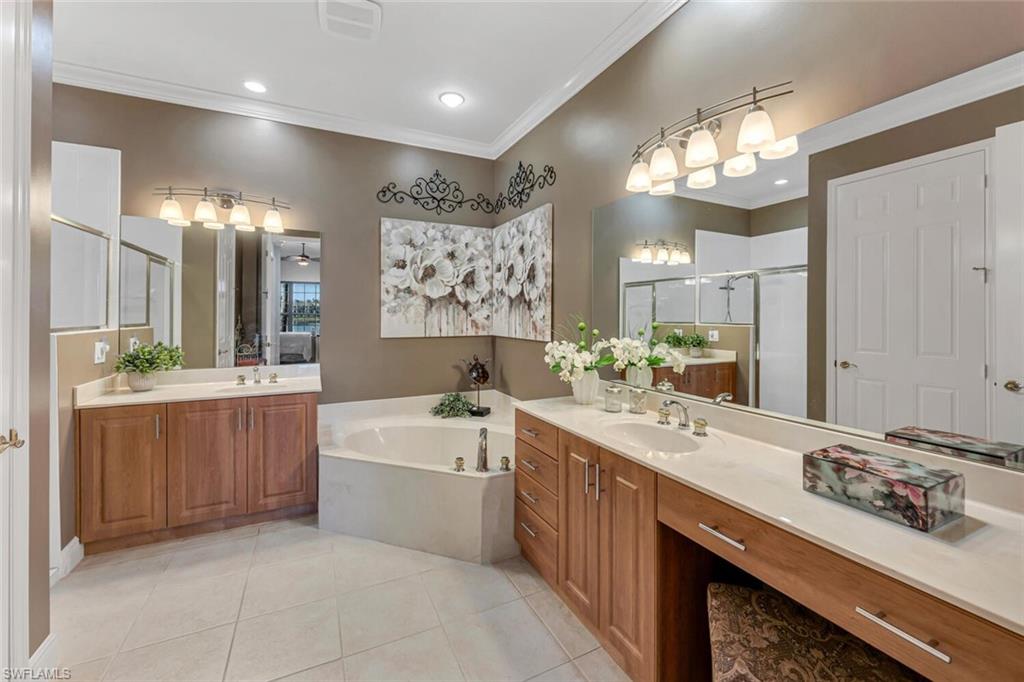 9243 Tesoro Lane, Unit 103 Naples, FL 34114 - Photo 16 of 18 a bathroom with a sink a large mirror and a shower