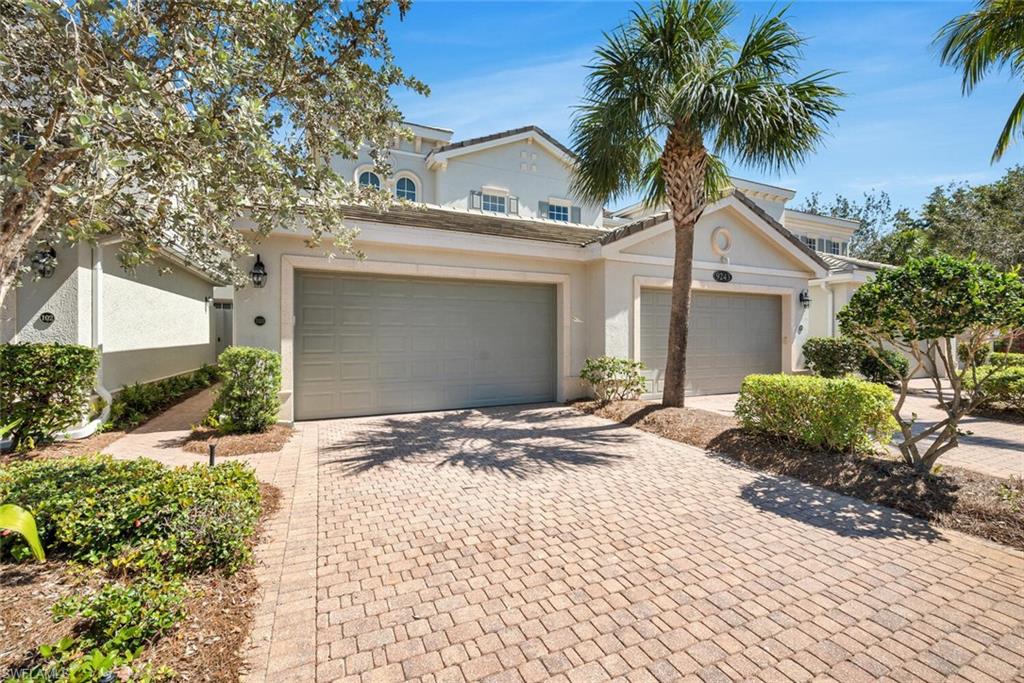 9243 Tesoro Lane, Unit 103 Naples, FL 34114 - Photo 3 of 18 a front view of a house with a yard and potted plants