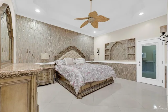 a spacious bedroom with a large bed and a chandelier