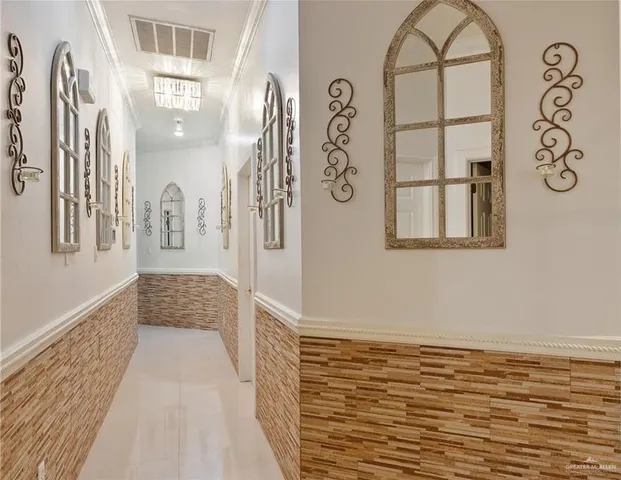 a hallway with painting on the wall and a large window