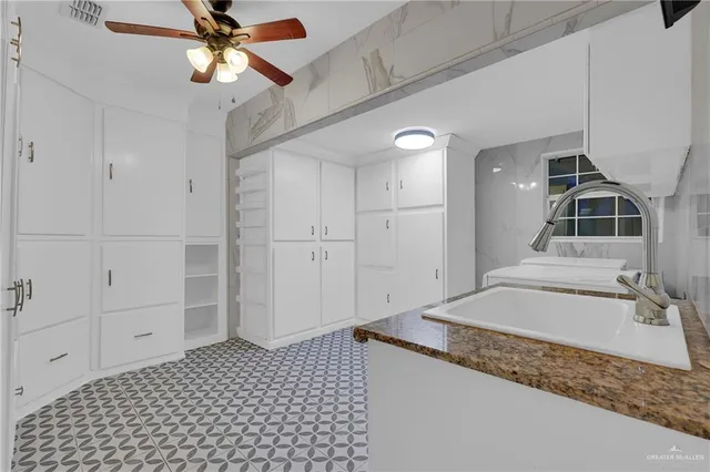 a bathroom with a granite countertop sink a mirror and shower