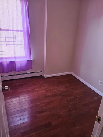 a view of a room with wooden floor and window