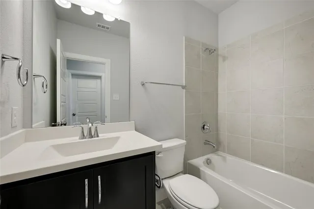 a bathroom with a sink toilet vanity and shower