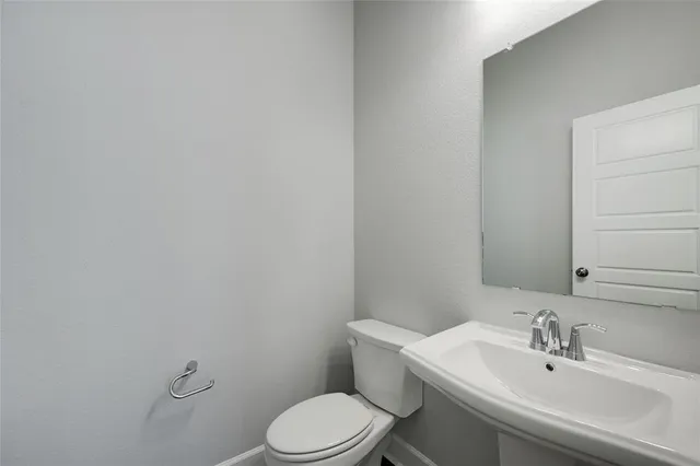a white toilet sitting next to a bathroom sink