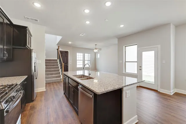 a kitchen with stainless steel appliances granite countertop a sink stove and refrigerator