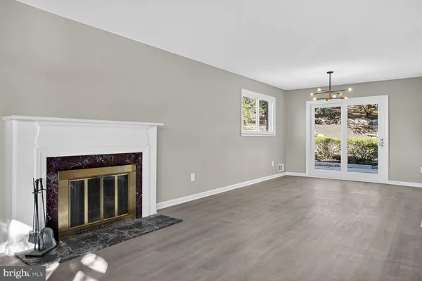 an empty room with windows and fireplace