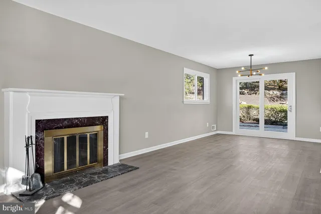 an empty room with windows and fireplace