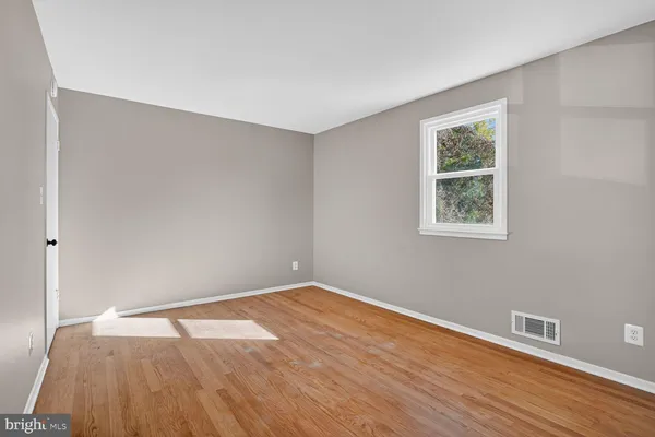 a view of empty room with wooden floor