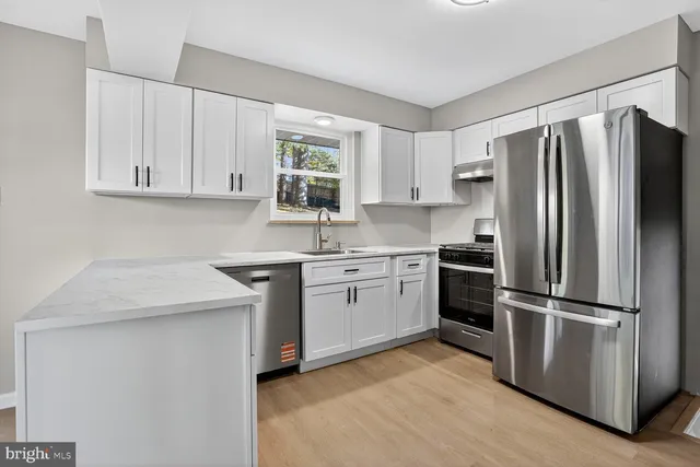 a kitchen with a refrigerator sink and cabinets
