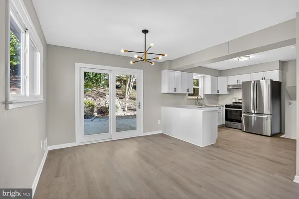 a view of kitchen with stainless steel appliances refrigerator oven and cabinets
