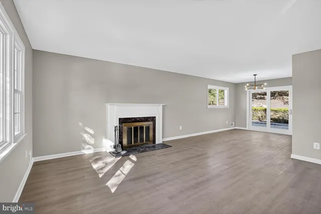 a view of empty room with fireplace and wooden floor