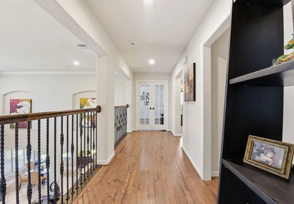 a view of a hallway with workspace and wooden floor