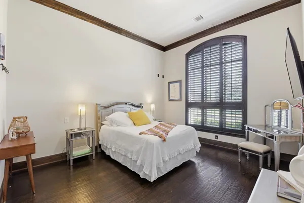 a bedroom with a bed wooden floor and window