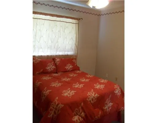a large bed sitting in a room next to a window