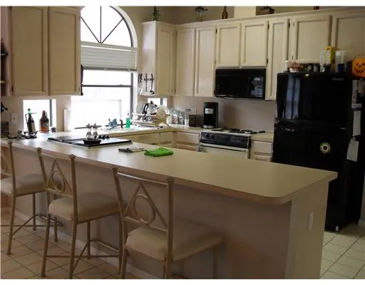 a kitchen with appliances a sink cabinets and a window