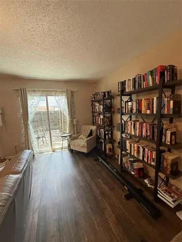 a living room with furniture a rug and a book shelf