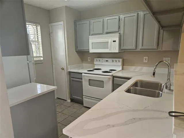 a kitchen with white cabinets and a sink