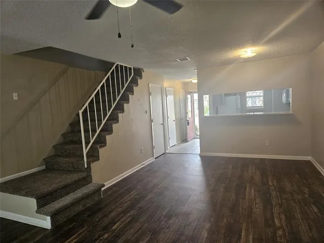 a view of an empty room with wooden floor and a cabinet