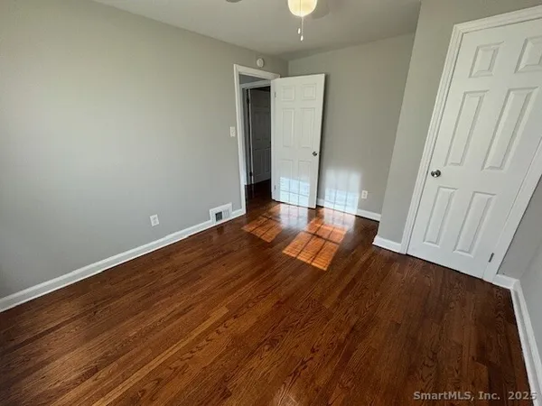 a view of an empty room with wooden floor