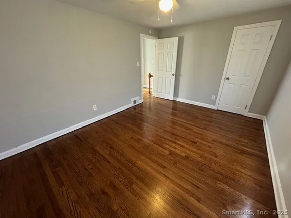 a view of an empty room with wooden floor