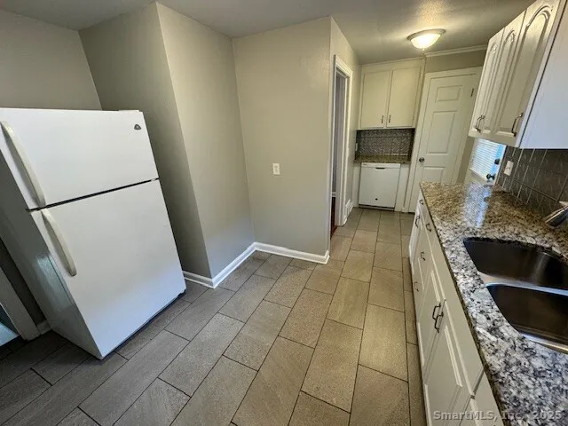a view of a kitchen with fridge and wooden floor
