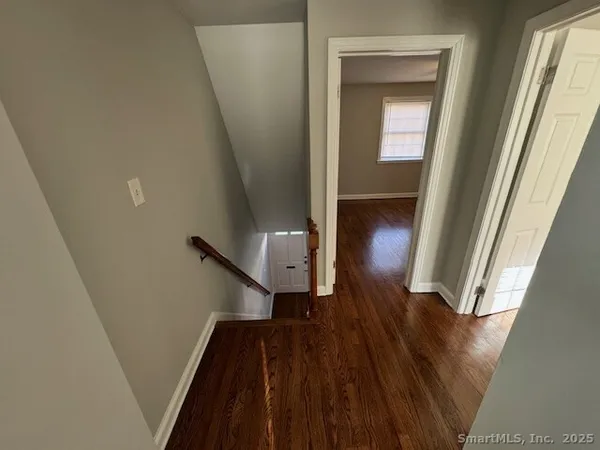 a view of entryway and hall with wooden floor