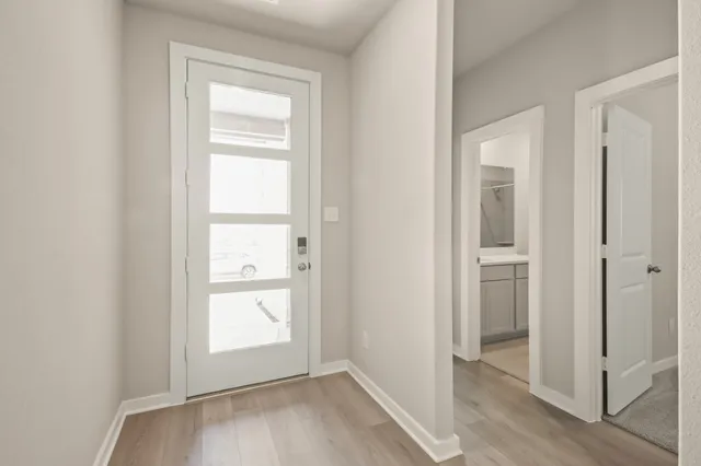 an empty room with wooden floor closet and windows