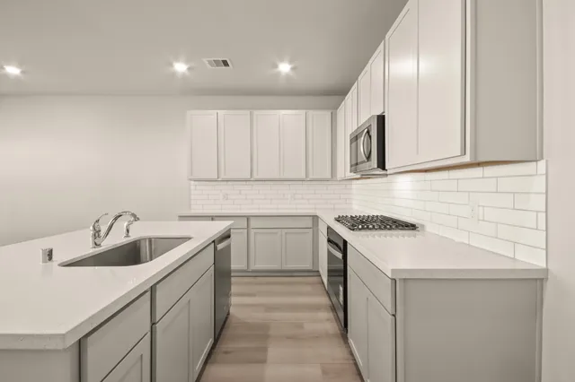 a kitchen that has a sink and a stove