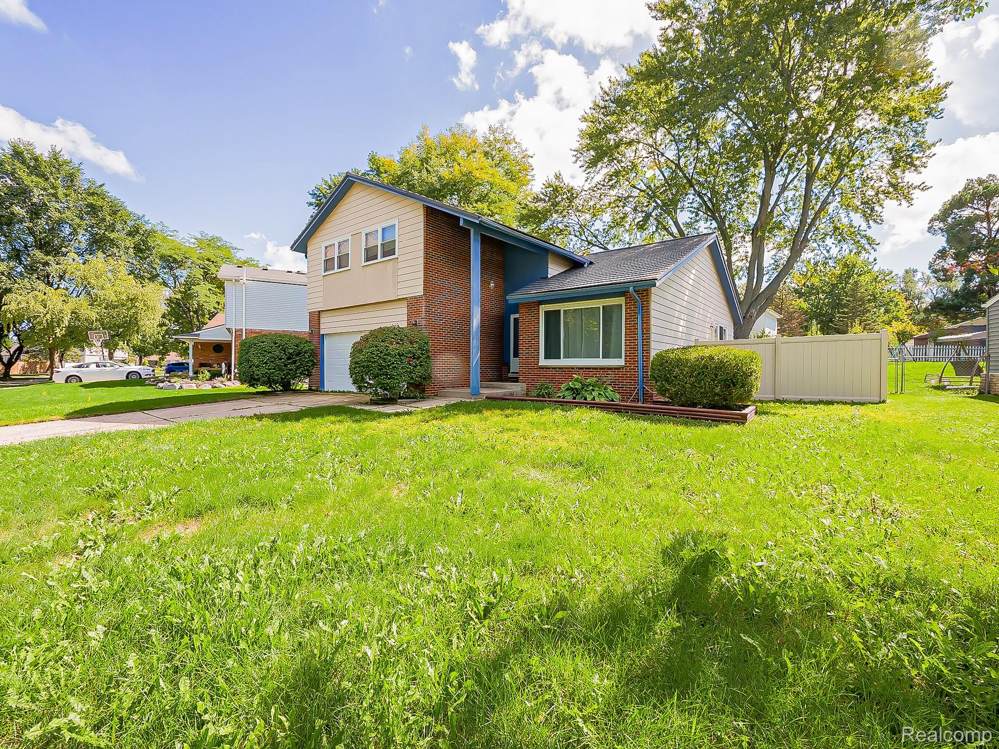 42195 Park Ridge Road Novi, MI 48375 - Photo 52 of 52 Split-level residence featuring a brick facade, light-toned siding, and an attached garage