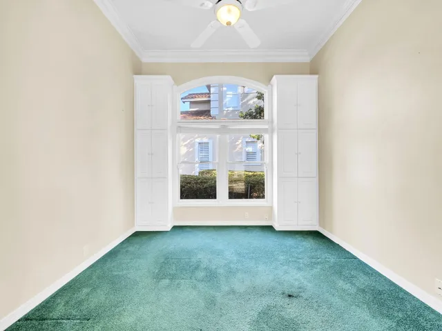 an empty room with a window and a ceiling fan