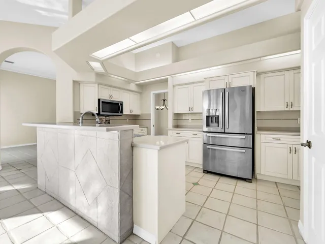 a view of a big room with windows and chandelier fan