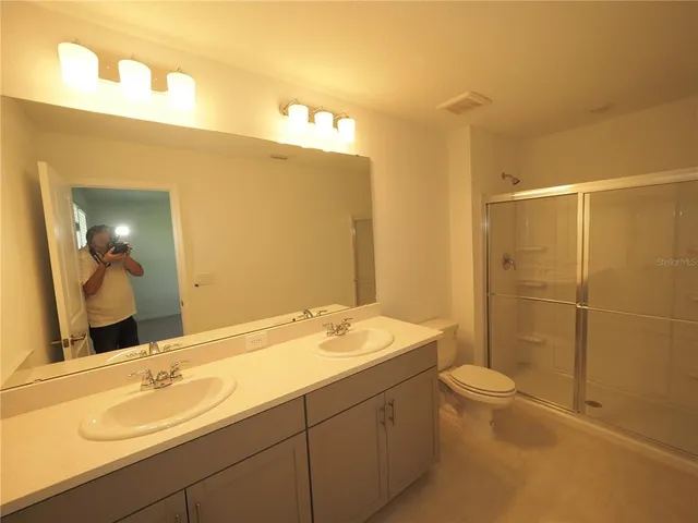 a bathroom with a granite countertop sink a toilet and a mirror