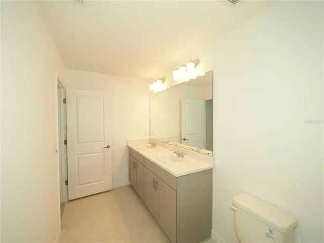 a bathroom with a sink a toilet and mirror