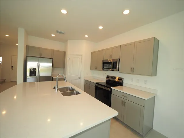 a kitchen with stainless steel appliances a sink stove and refrigerator