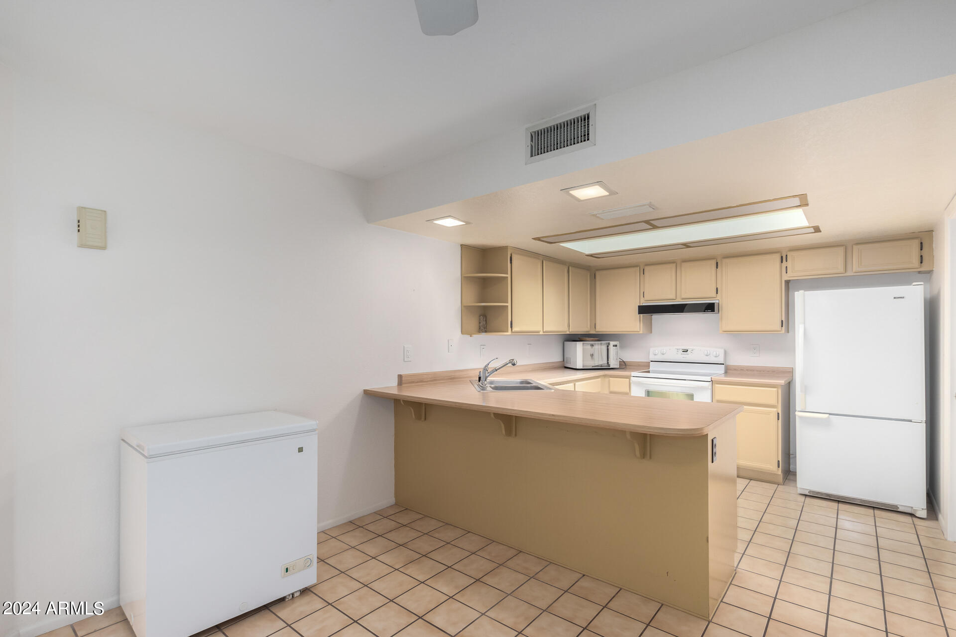 18035 North 24th Place Phoenix, AZ 85032 - Photo 5 of 22 a kitchen with a sink a stove a refrigerator and white cabinets