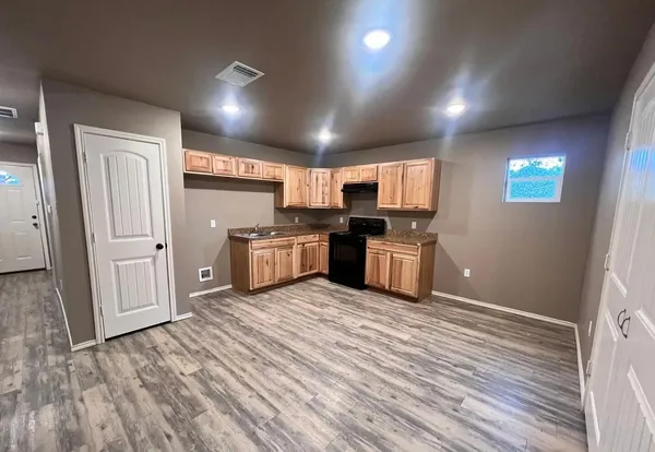 a kitchen with granite countertop a refrigerator and a stove top oven