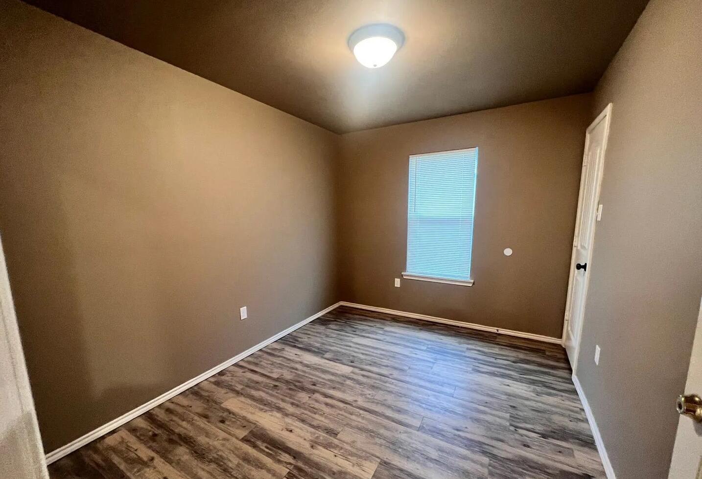 1516 East 8th Street Lubbock, TX 79403 - Photo 4 of 7 an empty room with wooden floor and windows
